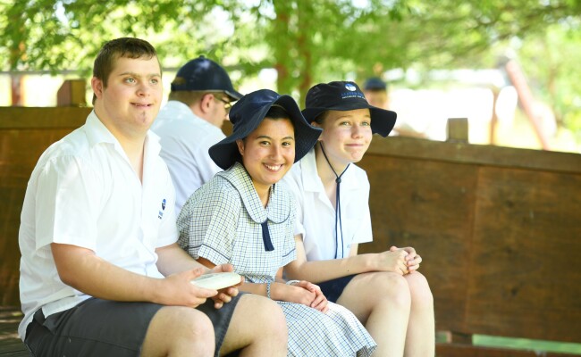 Students in shade smiling